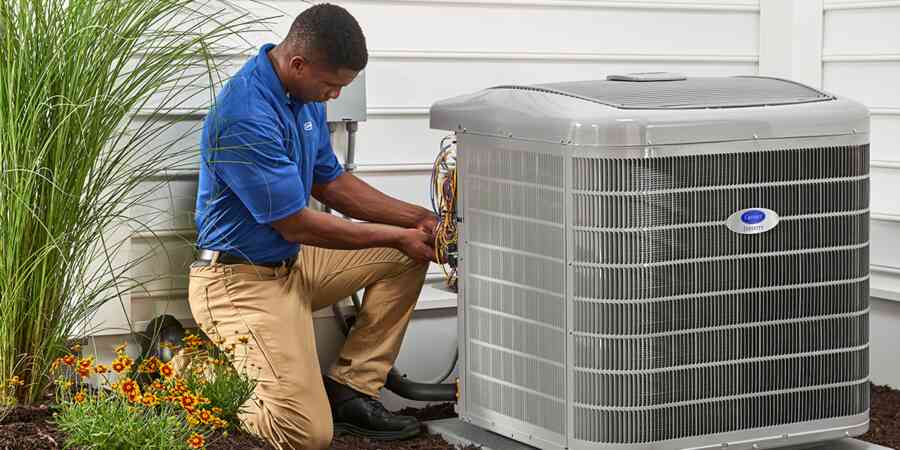Man installing heat pump next to house