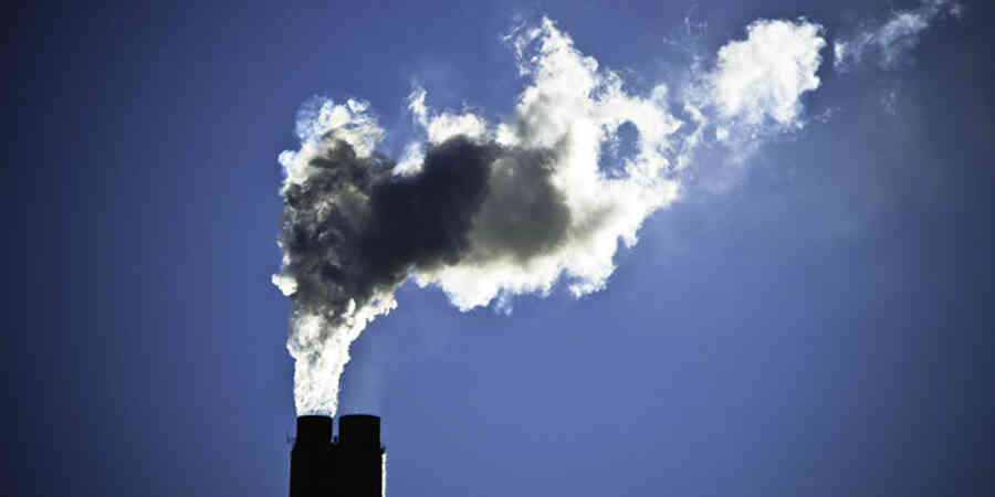 Smokestack against sun-lit sky