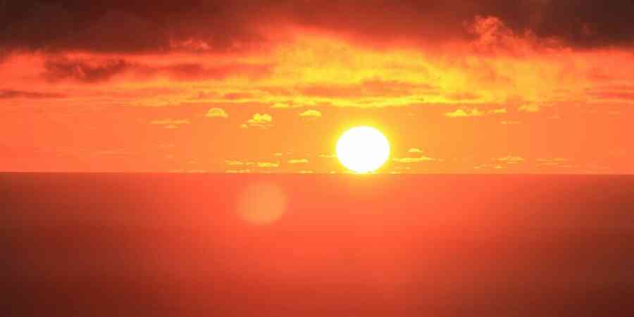 Setting or rising sun against slightly hazy sky